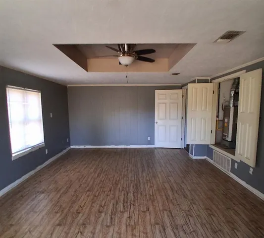 an empty room with wooden floor and windows