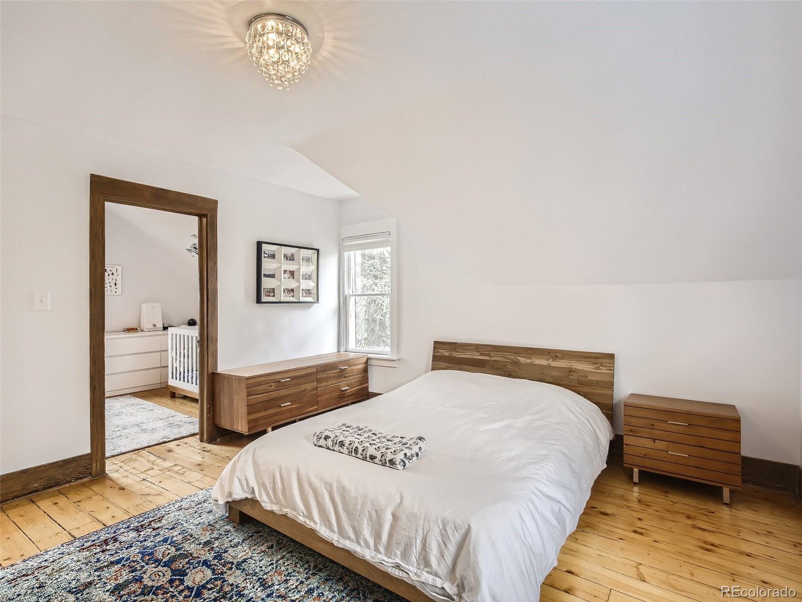 743 9th Street Boulder, CO 80302 - Photo 18 of 28 a bedroom with a bed and a chandelier