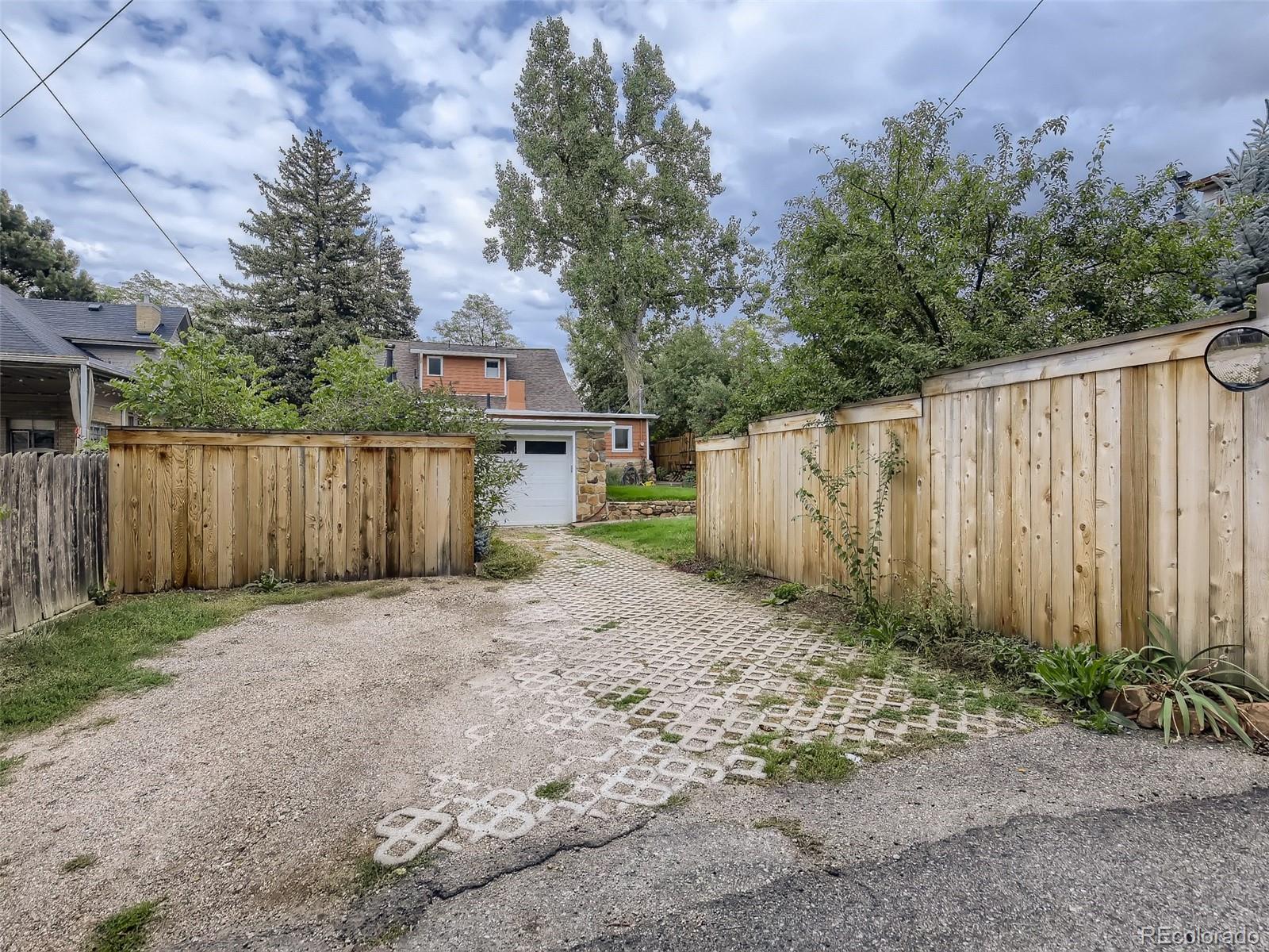 743 9th Street Boulder, CO 80302 - Photo 27 of 28 a view of a backyard with large trees and wooden fence
