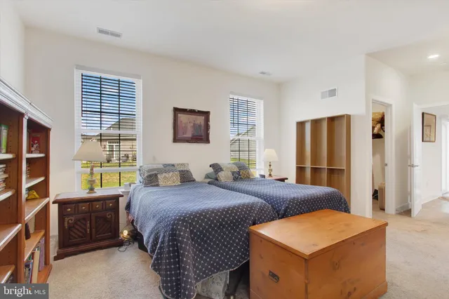 a bedroom with a bed and a dresser next to a window