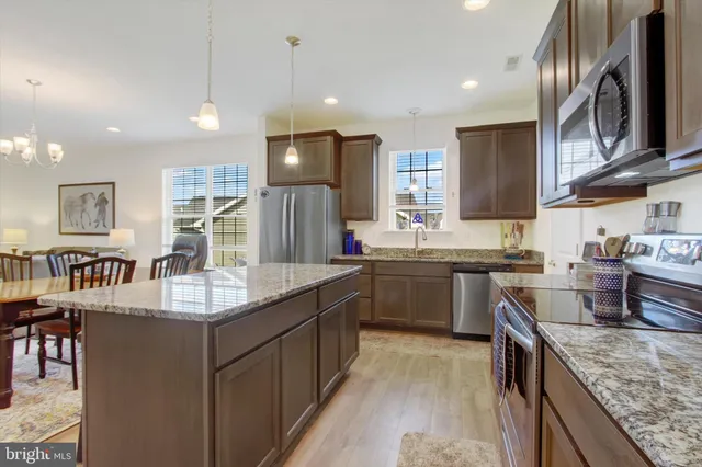 a kitchen with stainless steel appliances granite countertop sink stove top oven and refrigerator