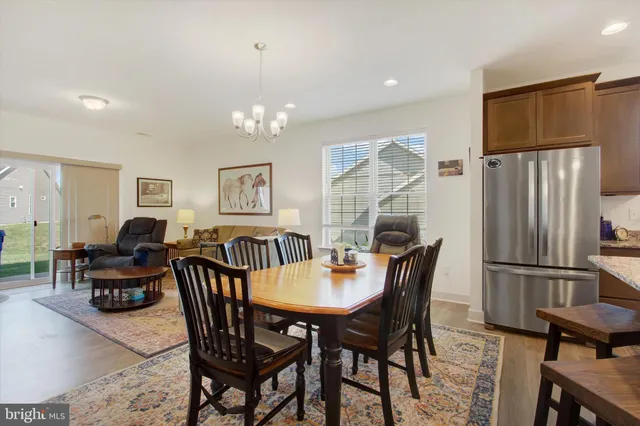 a dining room with furniture a chandelier and wooden floor