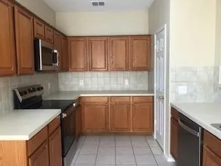 a kitchen with stainless steel appliances a stove a microwave a sink and cabinets