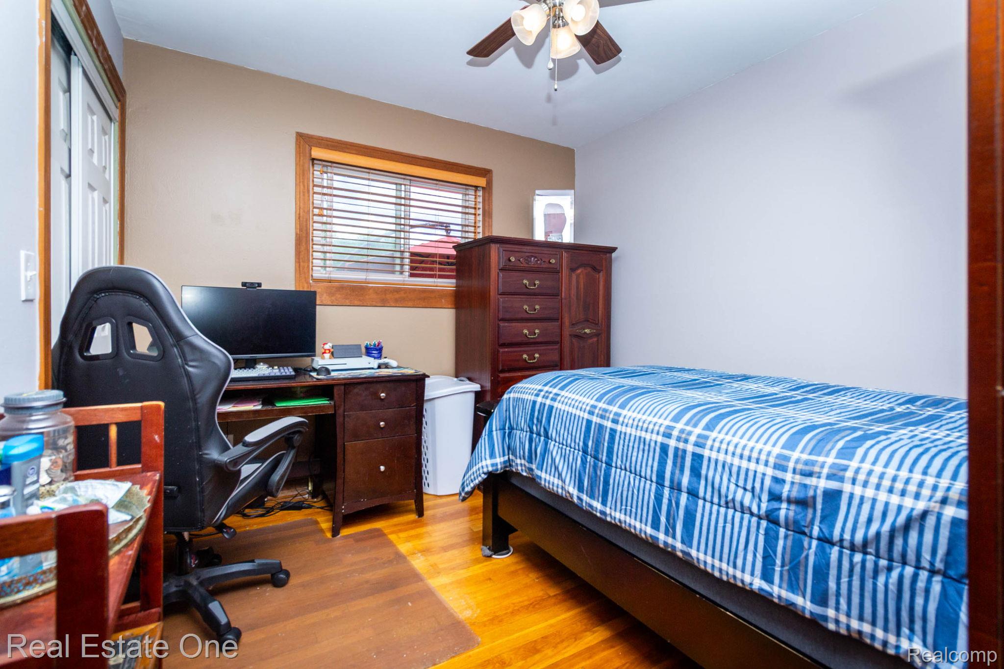 220 Winry Drive Rochester, MI 48307 - Photo 21 of 35 Room featuring wood-finish flooring, a window with blinds, a ceiling fan with light fixture, and a white interior door