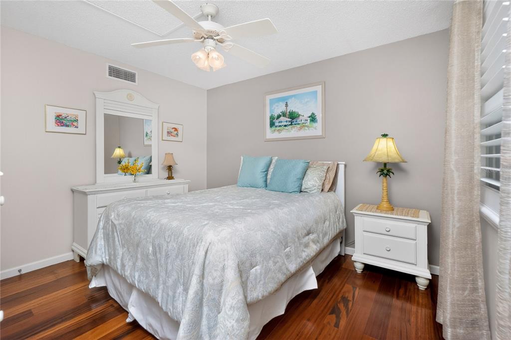 1501 Beach Road, Unit 210 Englewood, FL 34223 - Photo 30 of 62 a bedroom with a bed table and a chandelier