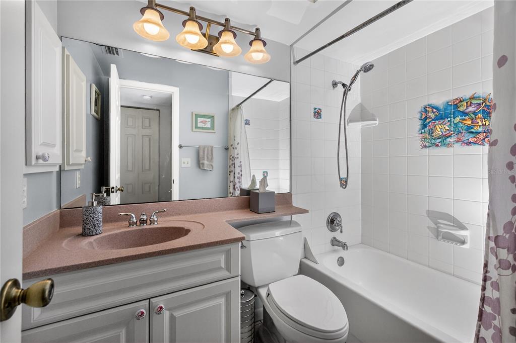 1501 Beach Road, Unit 210 Englewood, FL 34223 - Photo 31 of 62 a bathroom with a sink a toilet a mirror a bathtub and shower