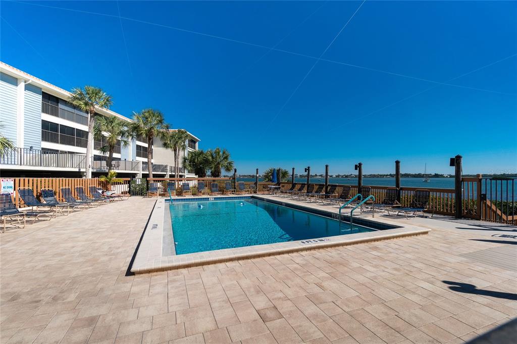 1501 Beach Road, Unit 210 Englewood, FL 34223 - Photo 43 of 62 a view of a swimming pool with a lounge chairs