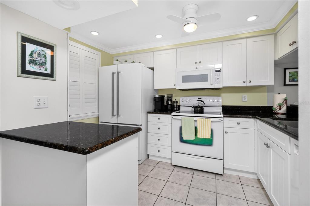 1501 Beach Road, Unit 210 Englewood, FL 34223 - Photo 8 of 62 a kitchen with stainless steel appliances granite countertop a refrigerator sink and stove
