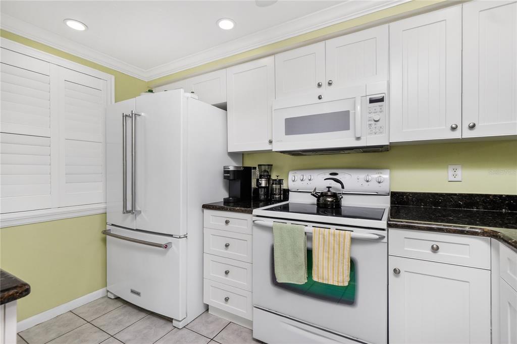1501 Beach Road, Unit 210 Englewood, FL 34223 - Photo 10 of 62 a kitchen with white cabinets and white appliances