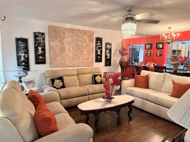 a living room with furniture kitchen view and a window