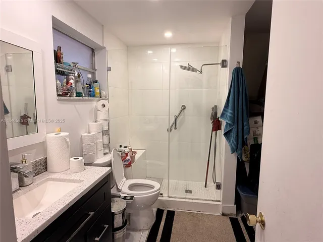 a living room with stainless steel appliances furniture a fireplace and a flat screen tv