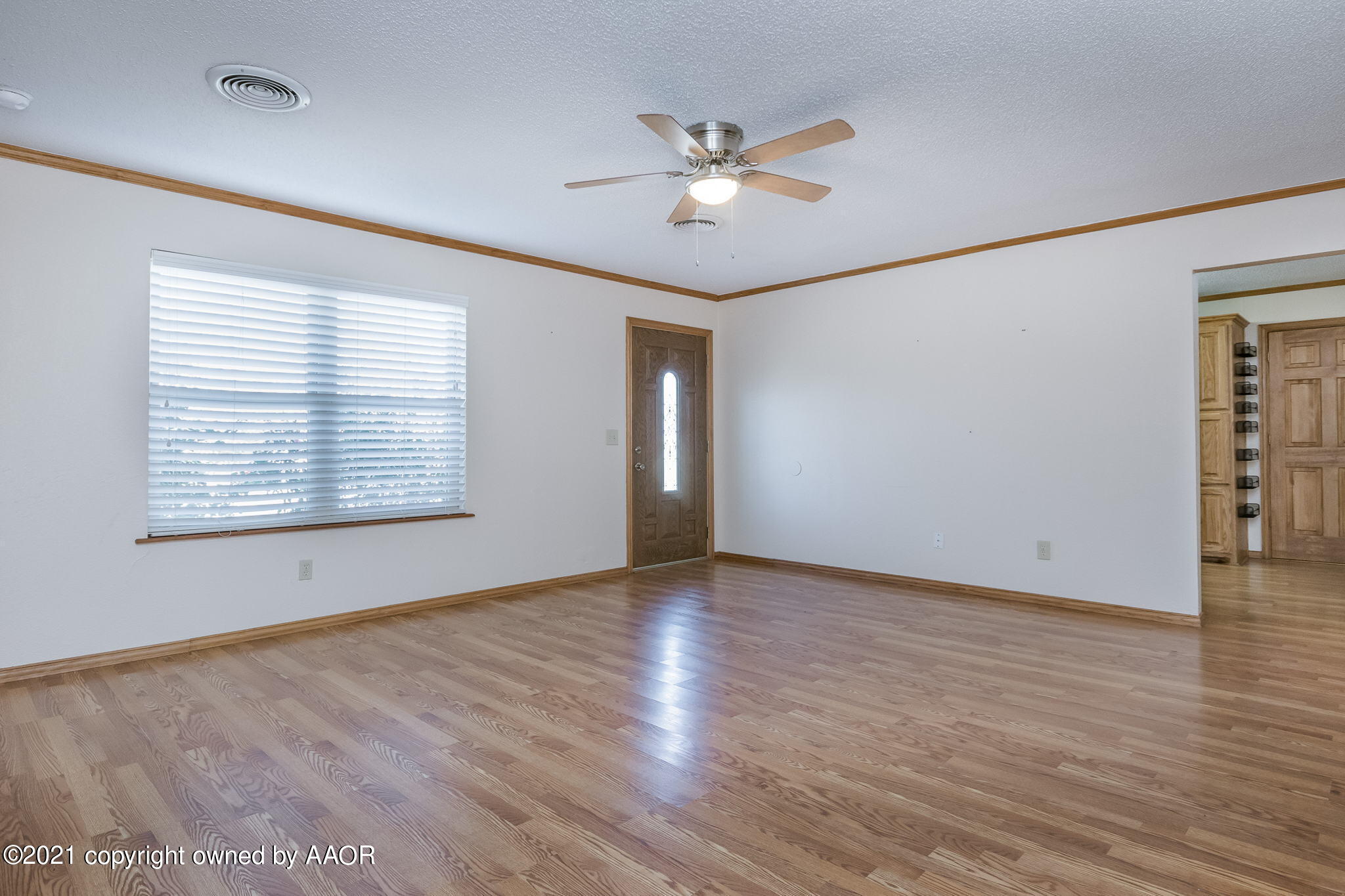 4809 South Rusk Street Amarillo, TX 79110 - Photo 2 of 17 an empty room with wooden floor chandelier fan and windows