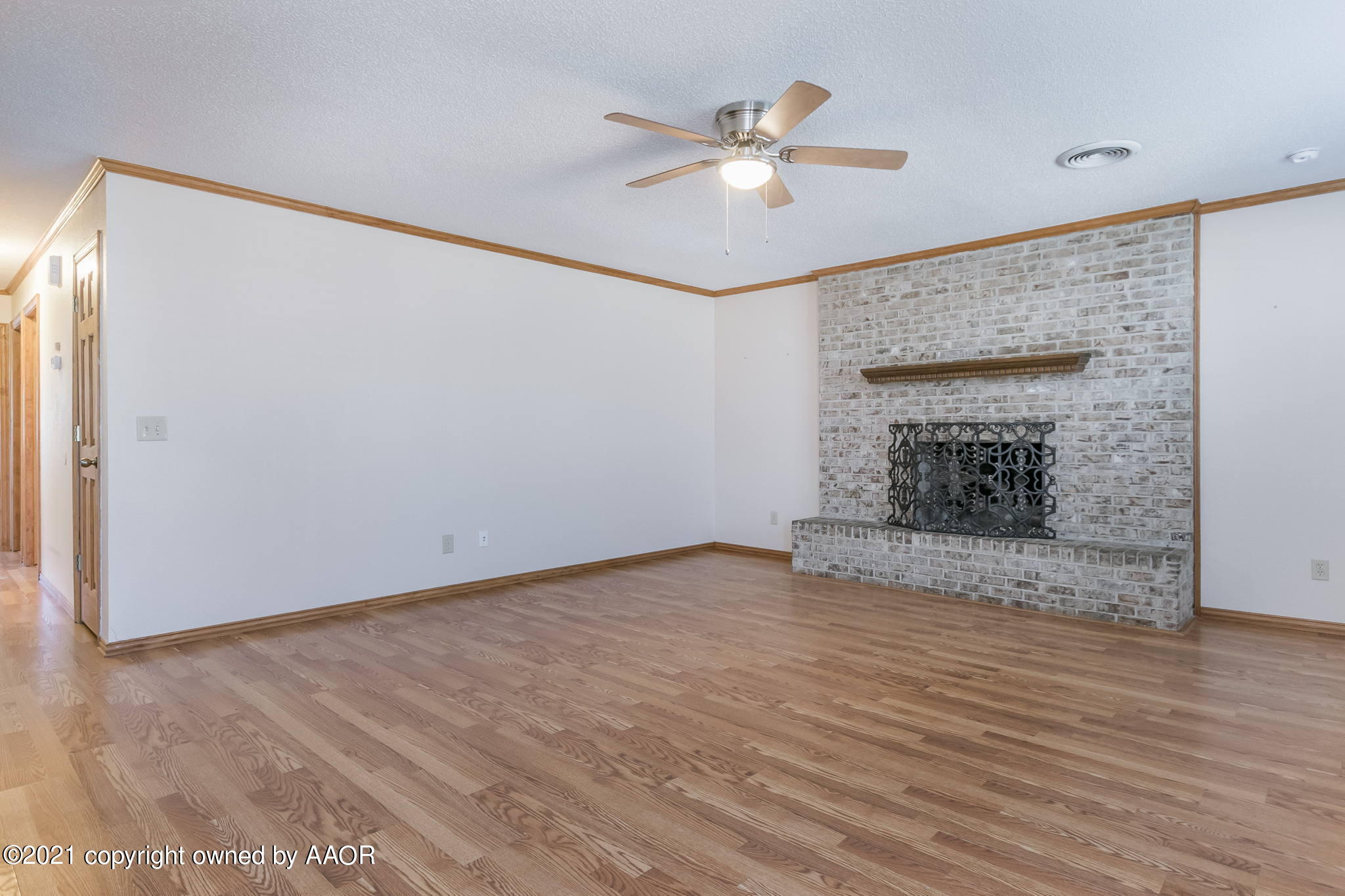 4809 South Rusk Street Amarillo, TX 79110 - Photo 3 of 17 a view of an empty room with wooden floor and a fireplace