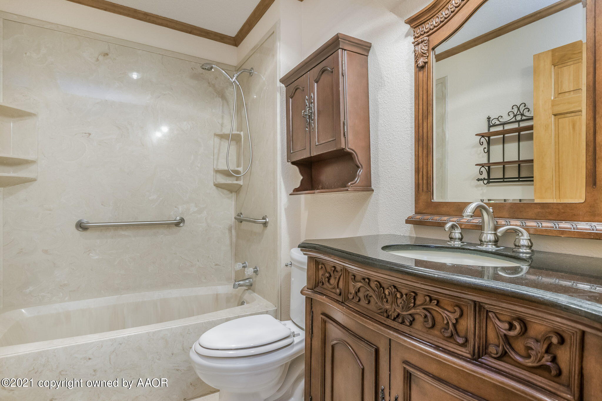 4809 South Rusk Street Amarillo, TX 79110 - Photo 8 of 17 a bathroom with a granite countertop sink a toilet a mirror a bathtub and shower