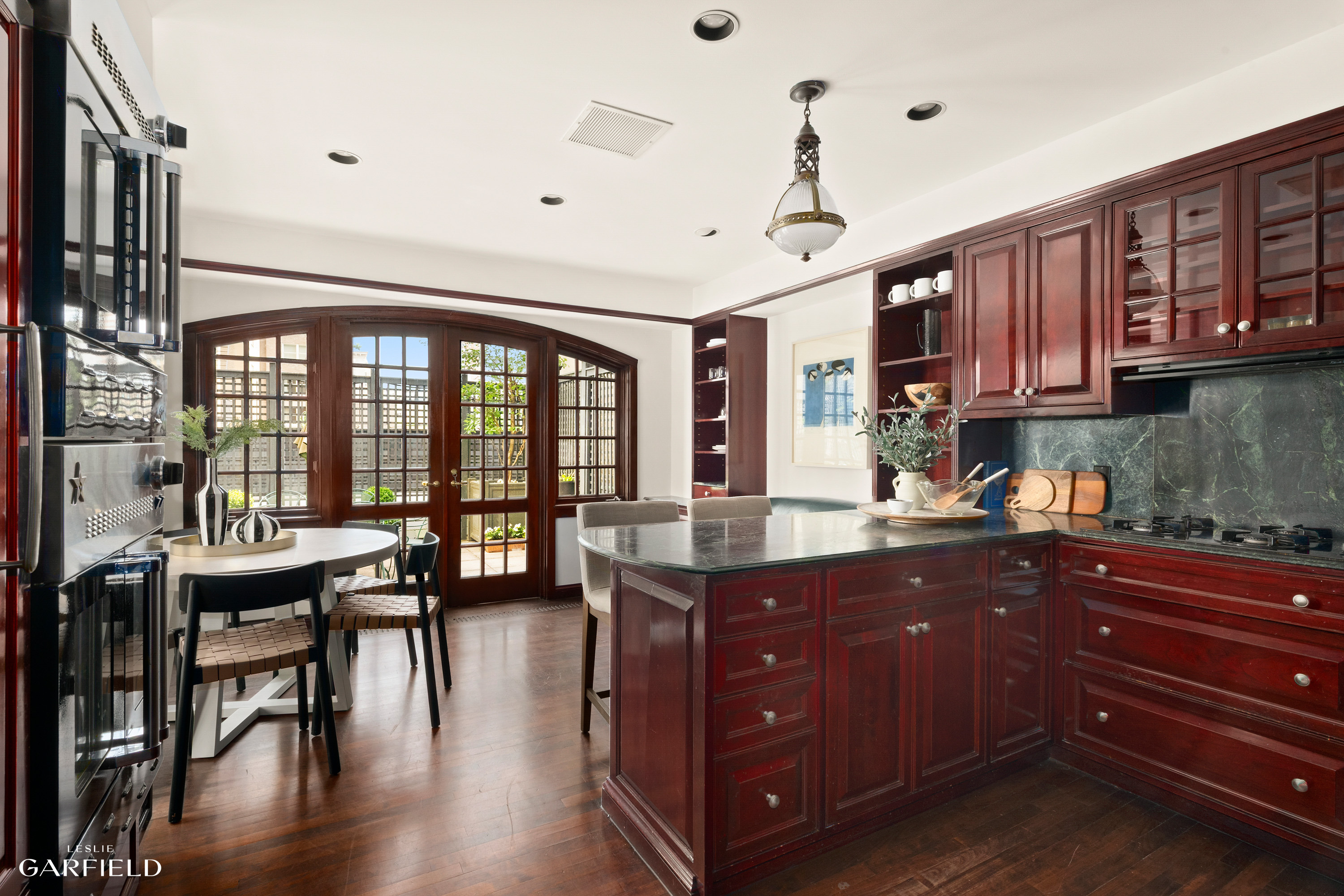 2 East 80th Street, Unit 7 Manhattan, NY 10075 - Photo 5 of 23 a kitchen with a table chairs stove and cabinets