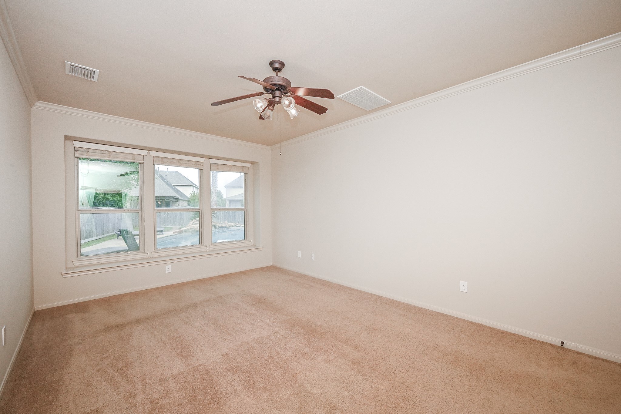 19 Sandwell Place Spring, TX 77389 - Photo 18 of 33 Primary suite featuring plush carpeting with ceiling fan for comfort and views of the resort style backyard