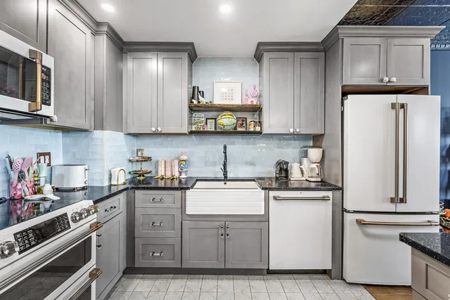 a kitchen with white cabinets and white appliances
