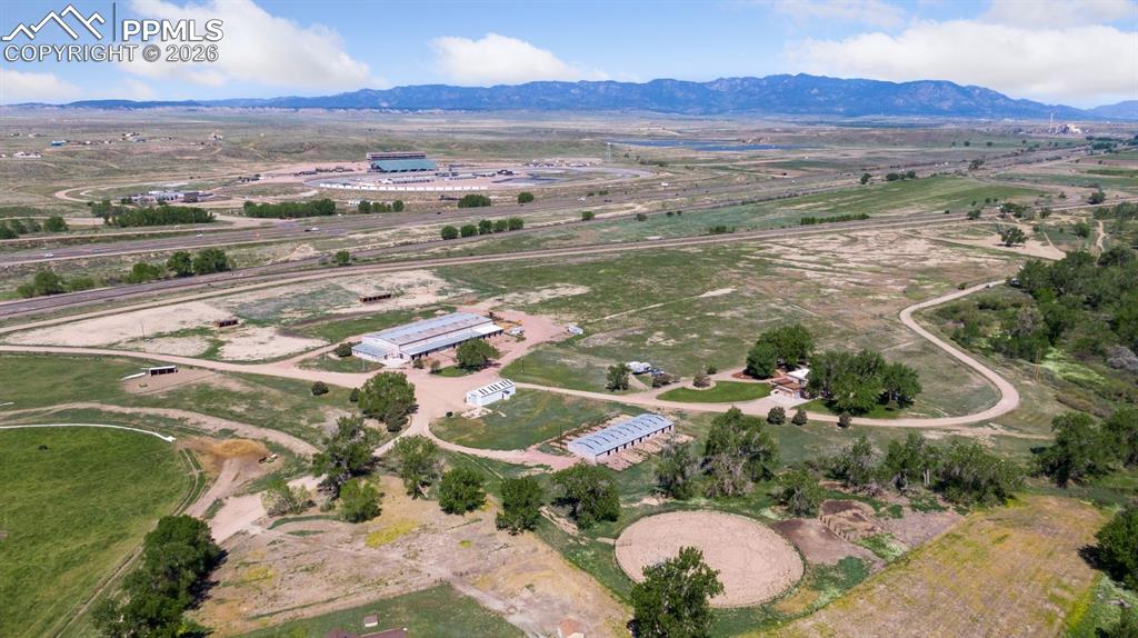 Aerial view of property's location featuring rural landscape, mountain backdrop, and overlook of Pikes Peak International Speedway