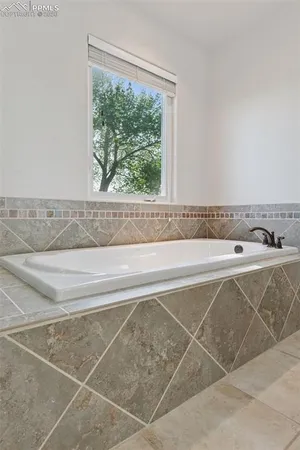 a bathroom with a bathtub and a window