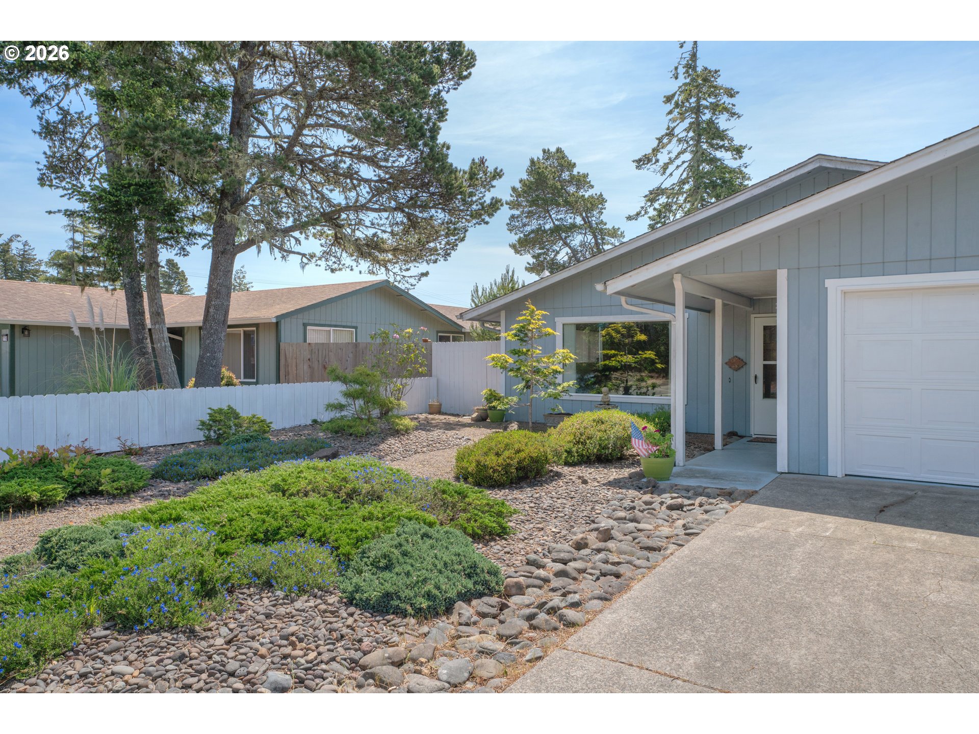 1142 9th Street Florence, OR 97439 - Photo 4 of 41 a front view of a house with garden