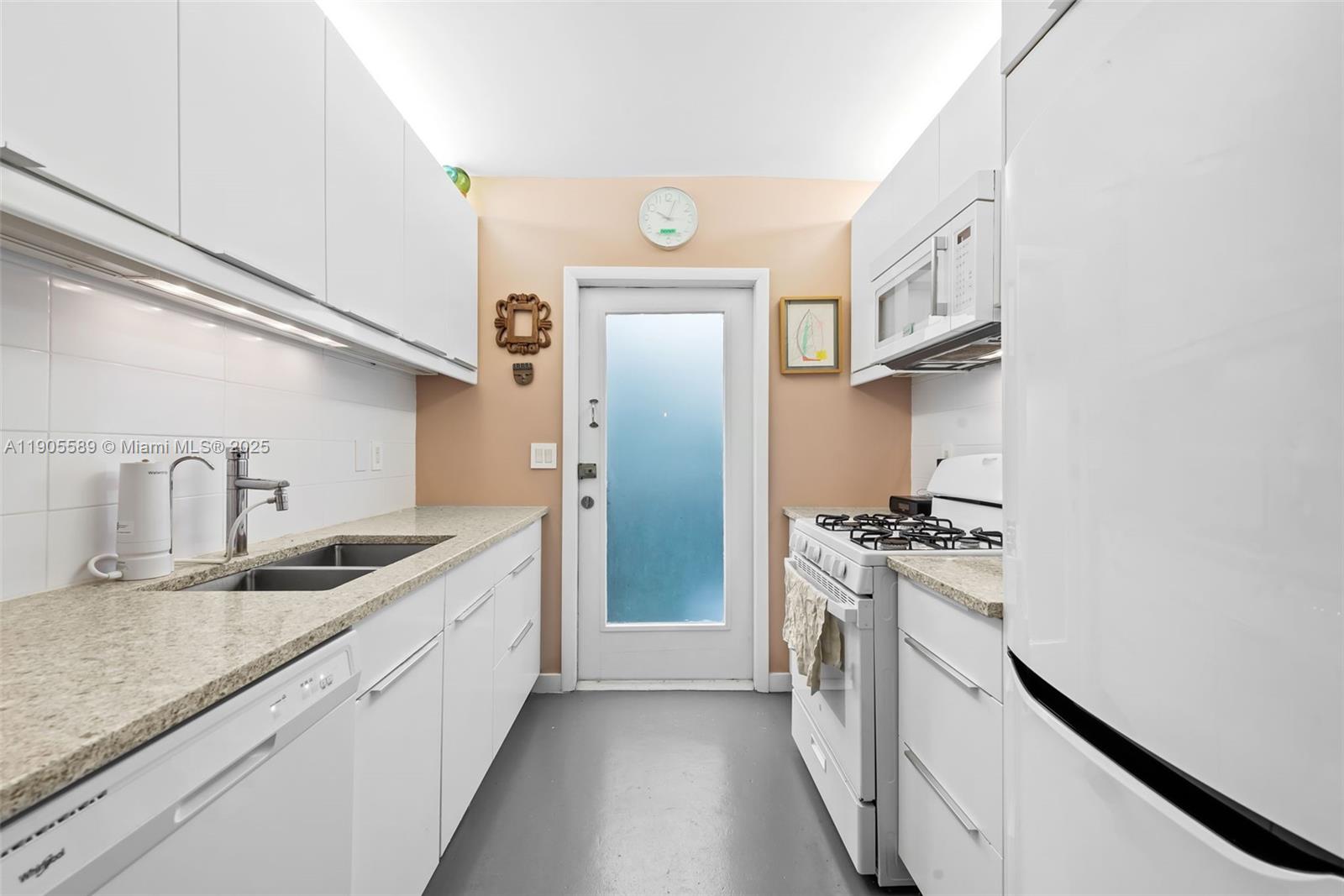 a kitchen with granite countertop a sink stove and refrigerator