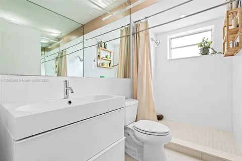 a white toilet sitting next to a bathroom sink