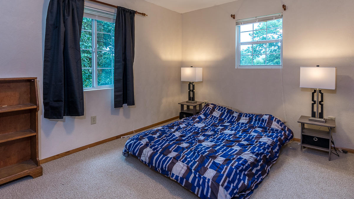 1136 Quarry Road Blue Ridge, VA 24064 - Photo 17 of 29 a bedroom with a bed a mirror and a window