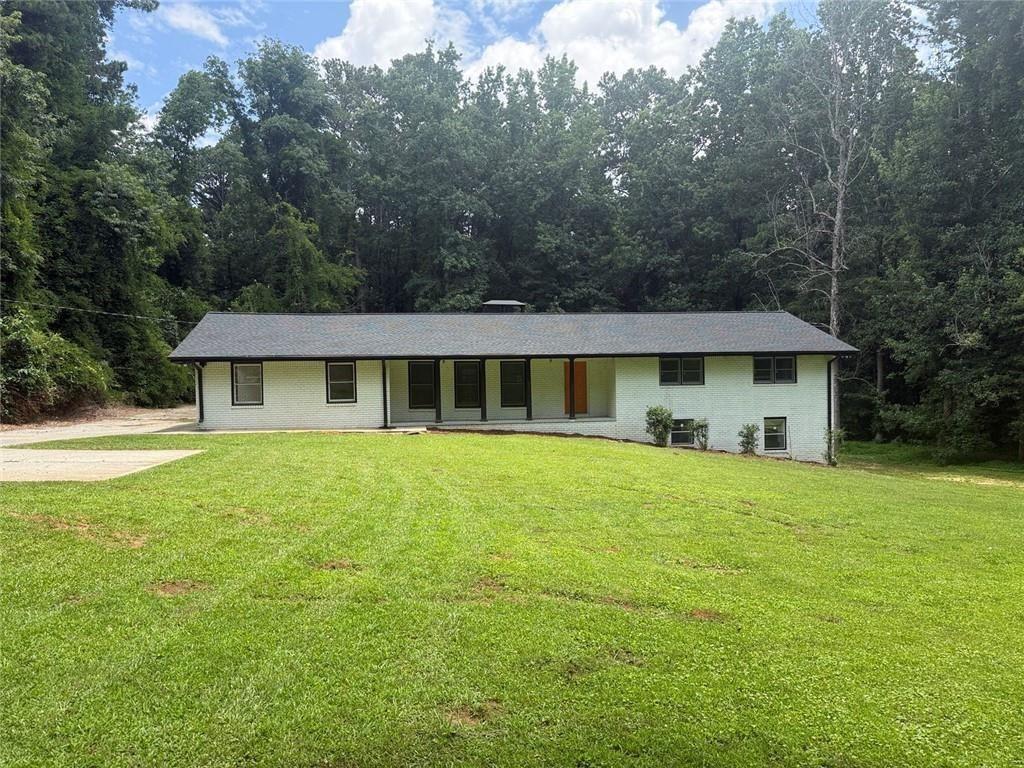 4330 Stonewall Tell Road Atlanta, GA 30349 - Photo 1 of 39 a front view of a house with a garden