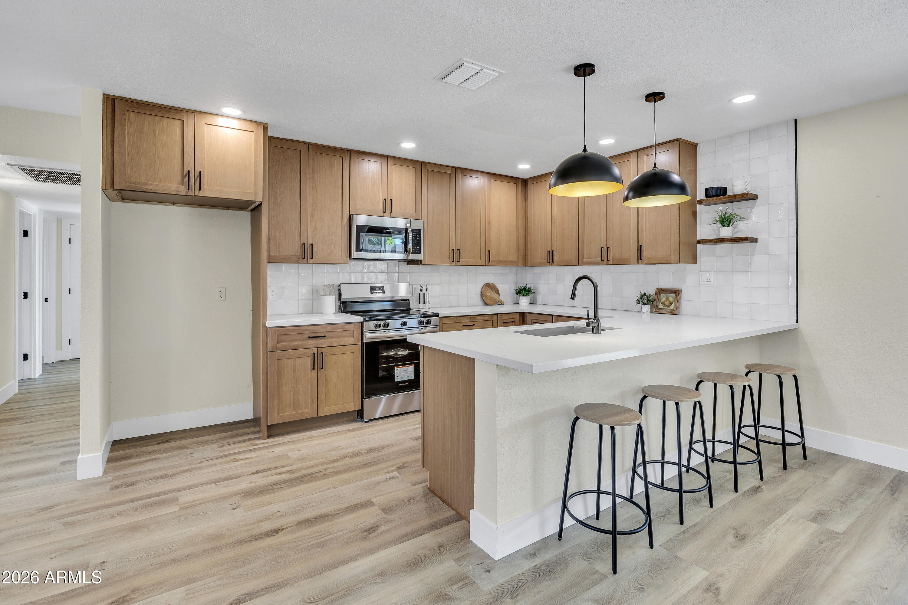 2123 East Radcliffe Drive Tempe, AZ 85283 - Photo 6 of 25 a kitchen with kitchen island granite countertop a sink cabinets and wooden floor