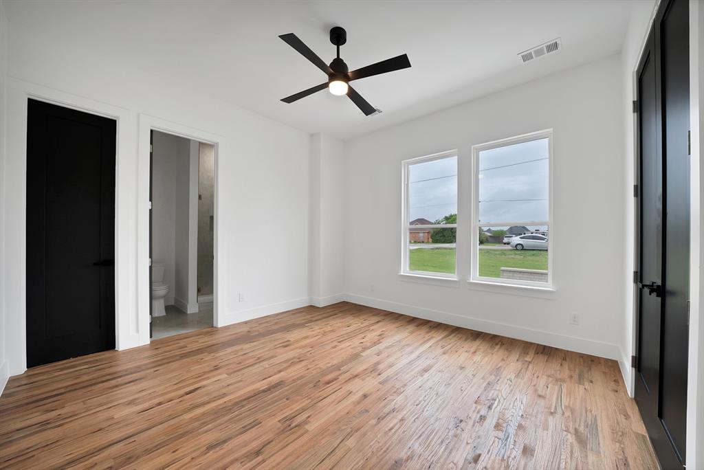 710 Gibson Road Waxahachie, TX 75165 - Photo 23 of 36 This room features wood-look flooring, white walls, and a ceiling fan with integrated lighting