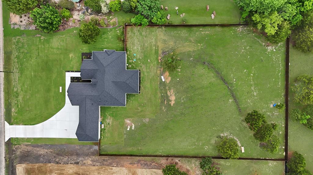 710 Gibson Road Waxahachie, TX 75165 - Photo 32 of 36 Expansive property featuring a dark roof, a light-colored driveway, and a large lawn area