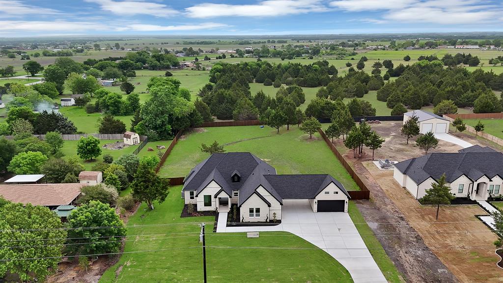 710 Gibson Road Waxahachie, TX 75165 - Photo 33 of 36 The property features a dark roof, a light-colored exterior, an attached garage, and a concrete driveway