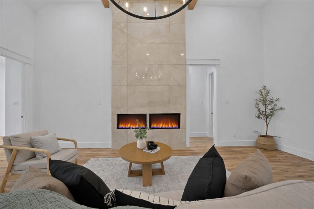 710 Gibson Road Waxahachie, TX 75165 - Photo 7 of 36 This inviting living space features high ceilings, light hardwood floors, and a modern fireplace with two inserts