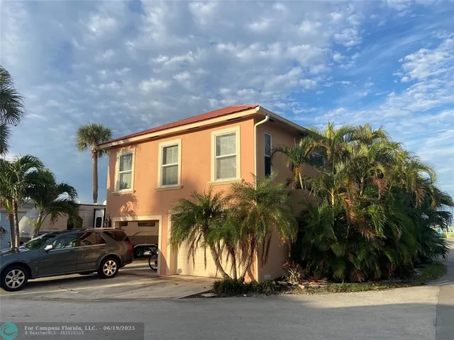 a view of backyard with a car parked in front of it