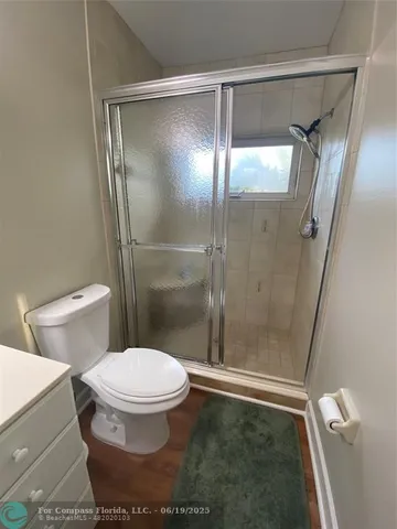 a bathroom with a toilet and a glass shower door