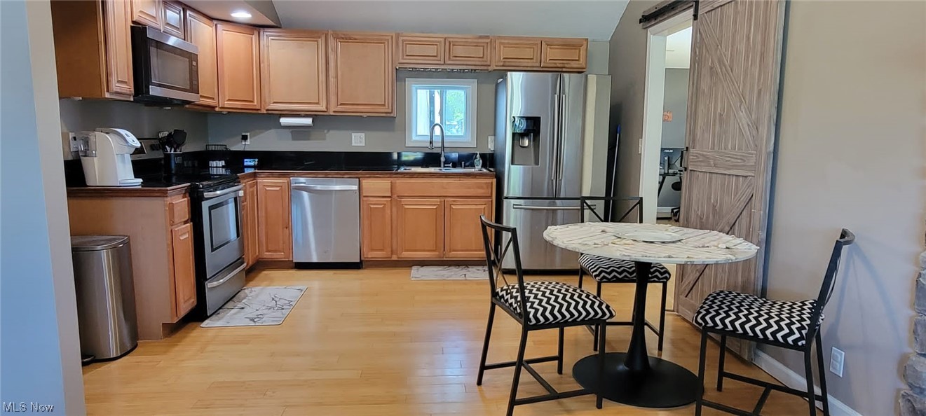 5770 Jaycox Road North Ridgeville, OH 44039 - Photo 7 of 31 Kitchen with brown cabinets, light parquet floors, and stainless steel appliances