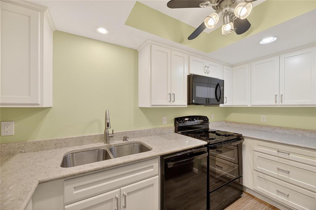 1028 Apollo Beach Boulevard, Unit 23 Apollo Beach, FL 33572 - Photo 18 of 86 a kitchen with stainless steel appliances granite countertop a sink and a stove