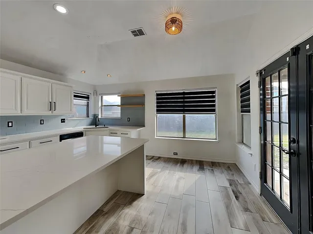 a large kitchen with a large window a sink and stainless steel appliances