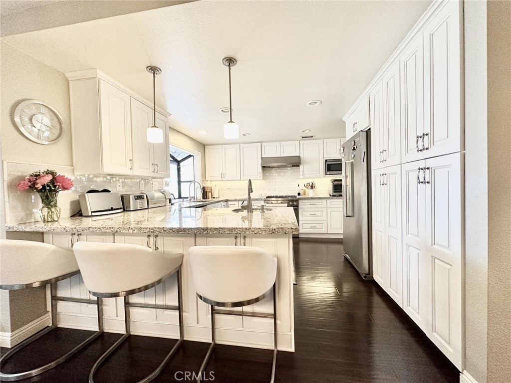 2138 Clear Springs Road Brea, CA 92821 - Photo 6 of 10 a kitchen with stainless steel appliances a dining table chairs and a refrigerator