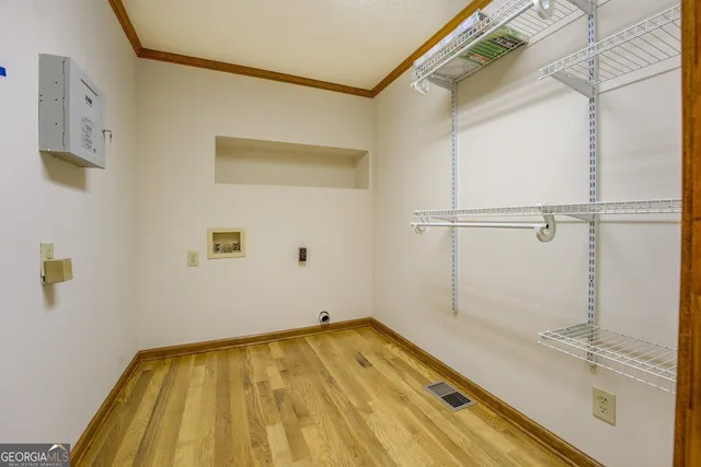 a view of an empty room with wooden floor and closet