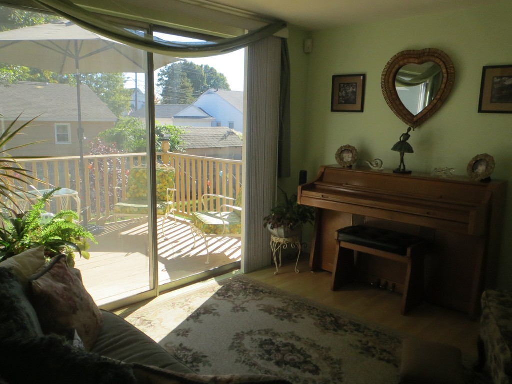 84 Genesee Street Lawrence, MA 01843 - Photo 11 of 30 a living room with a balcony a bed furniture and a large window