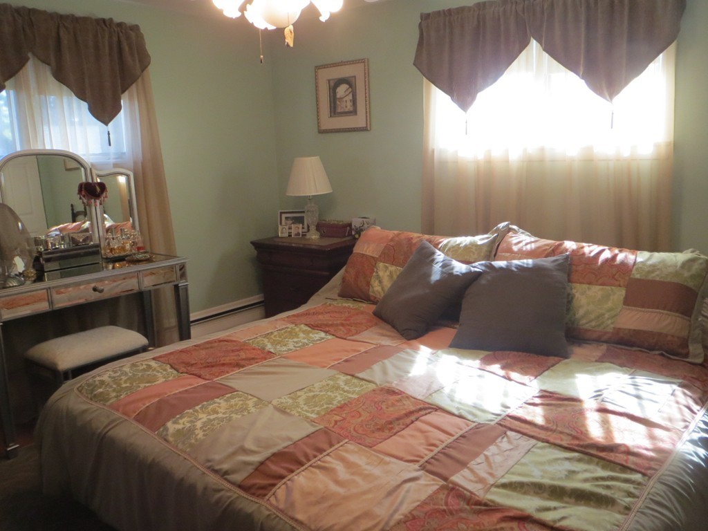 84 Genesee Street Lawrence, MA 01843 - Photo 16 of 30 a bed sitting in a bedroom next to a window