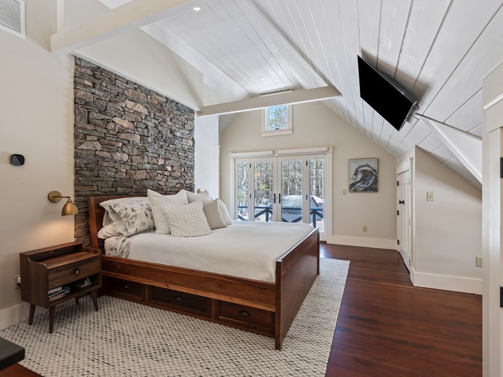 49 Greene Road Princeton, MA 01541 - Photo 28 of 42 a bedroom with a large bed a flat tv screen and a dresser