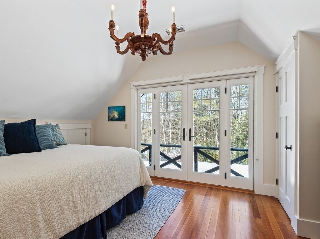 49 Greene Road Princeton, MA 01541 - Photo 31 of 42 a bedroom with a large bed and a chandelier