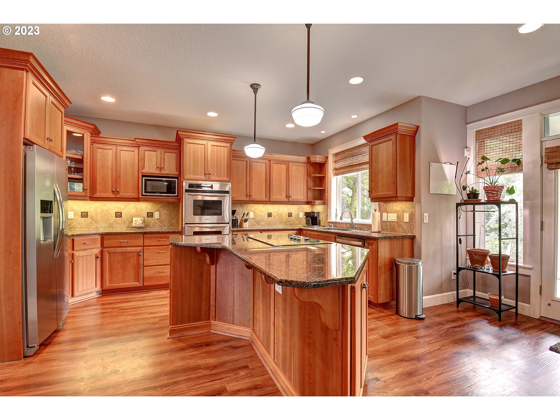907 North 7th Circle Ridgefield, WA 98642 - Photo 11 of 47 a kitchen with stainless steel appliances kitchen island granite countertop a stove refrigerator and a sink