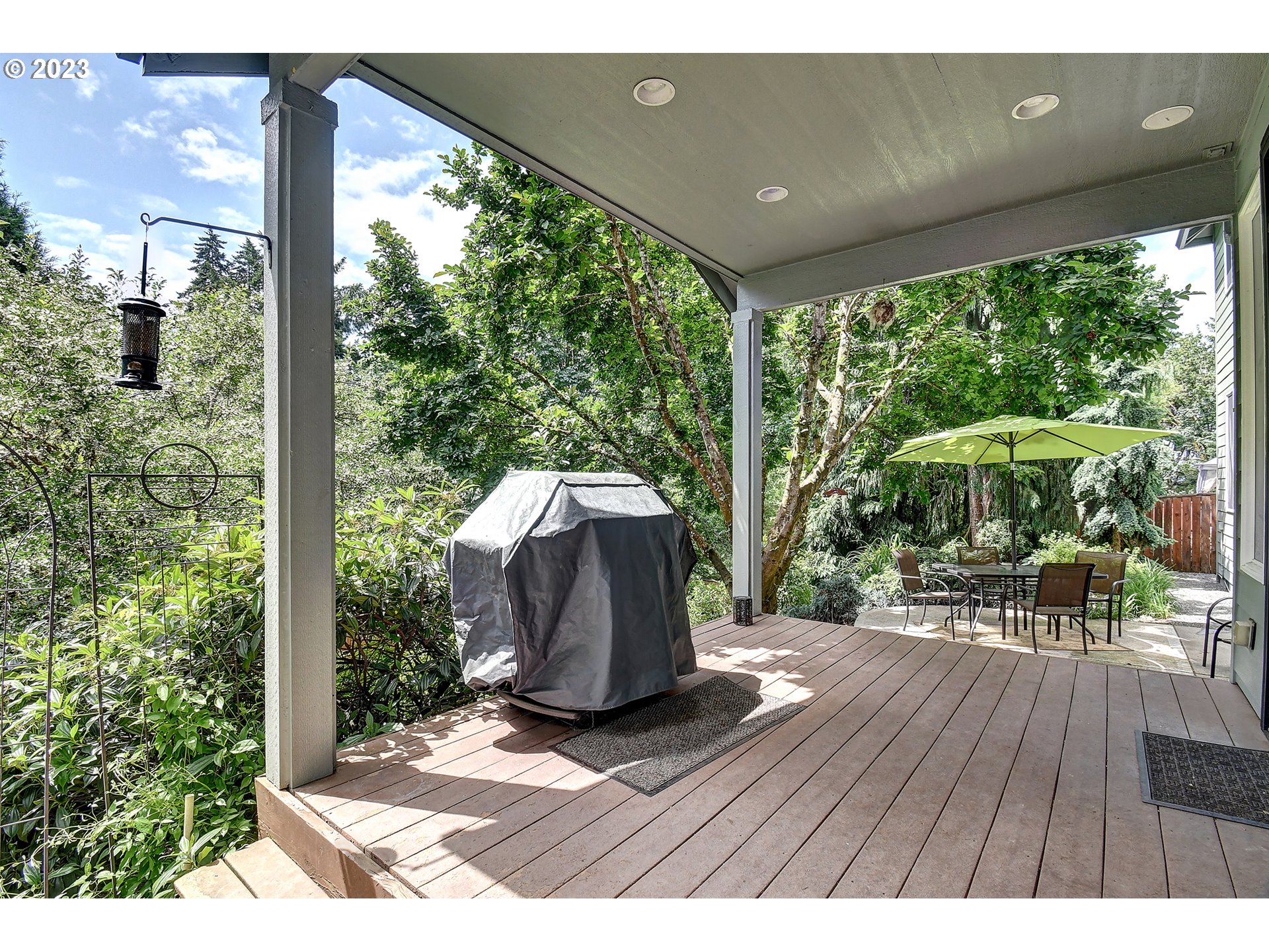 907 North 7th Circle Ridgefield, WA 98642 - Photo 36 of 47 a view of a patio with table and chairs under an umbrella with wooden floor