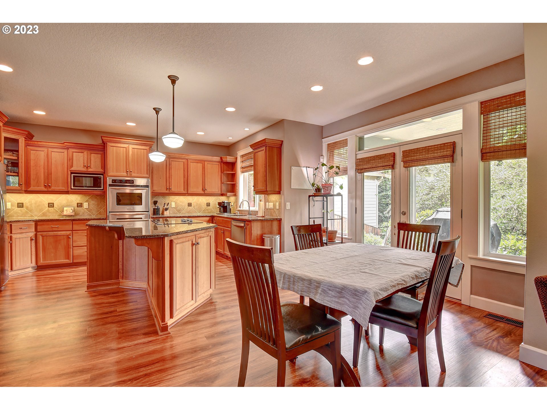 907 North 7th Circle Ridgefield, WA 98642 - Photo 9 of 47 a dining room with stainless steel appliances kitchen island granite countertop a stove a sink a dining table and chairs