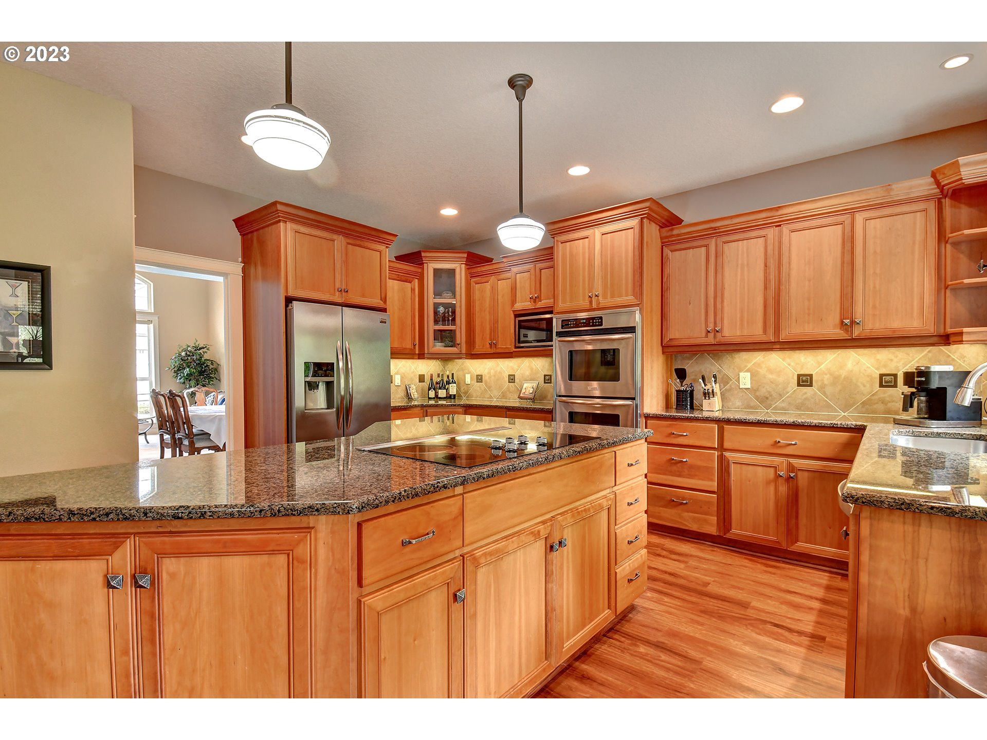 907 North 7th Circle Ridgefield, WA 98642 - Photo 10 of 47 a kitchen with stainless steel appliances granite countertop a sink a stove cabinets counter space and a view of living room