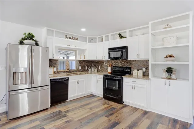 a kitchen with white cabinets and stainless steel appliances