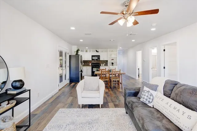 a living room with furniture and a view of kitchen